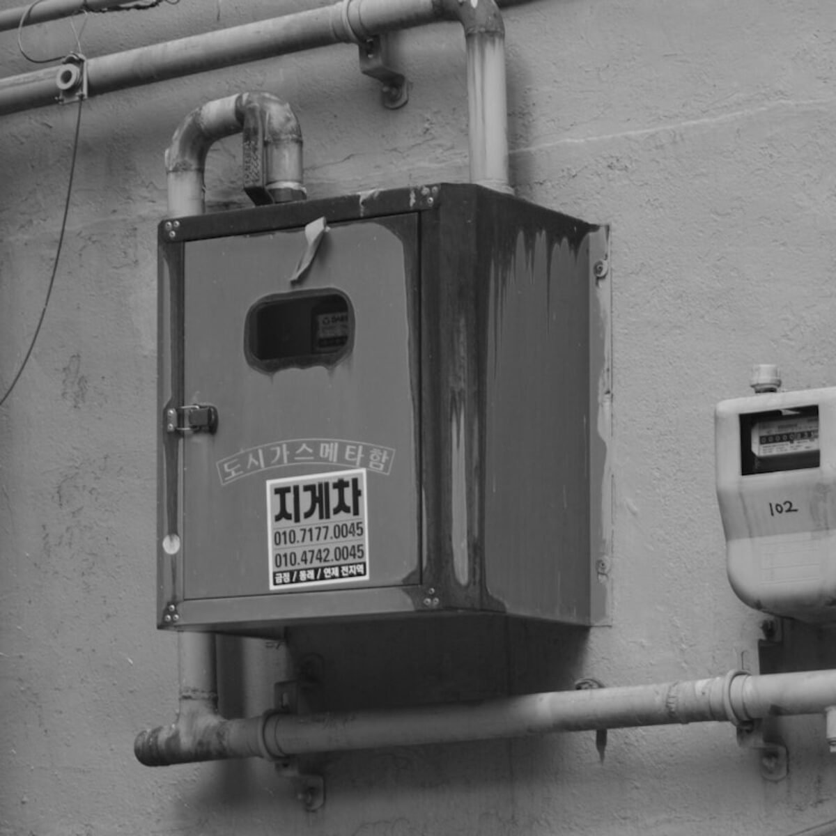 Gas meters and pipework fitted on a wall, square crop for gas leak response about section