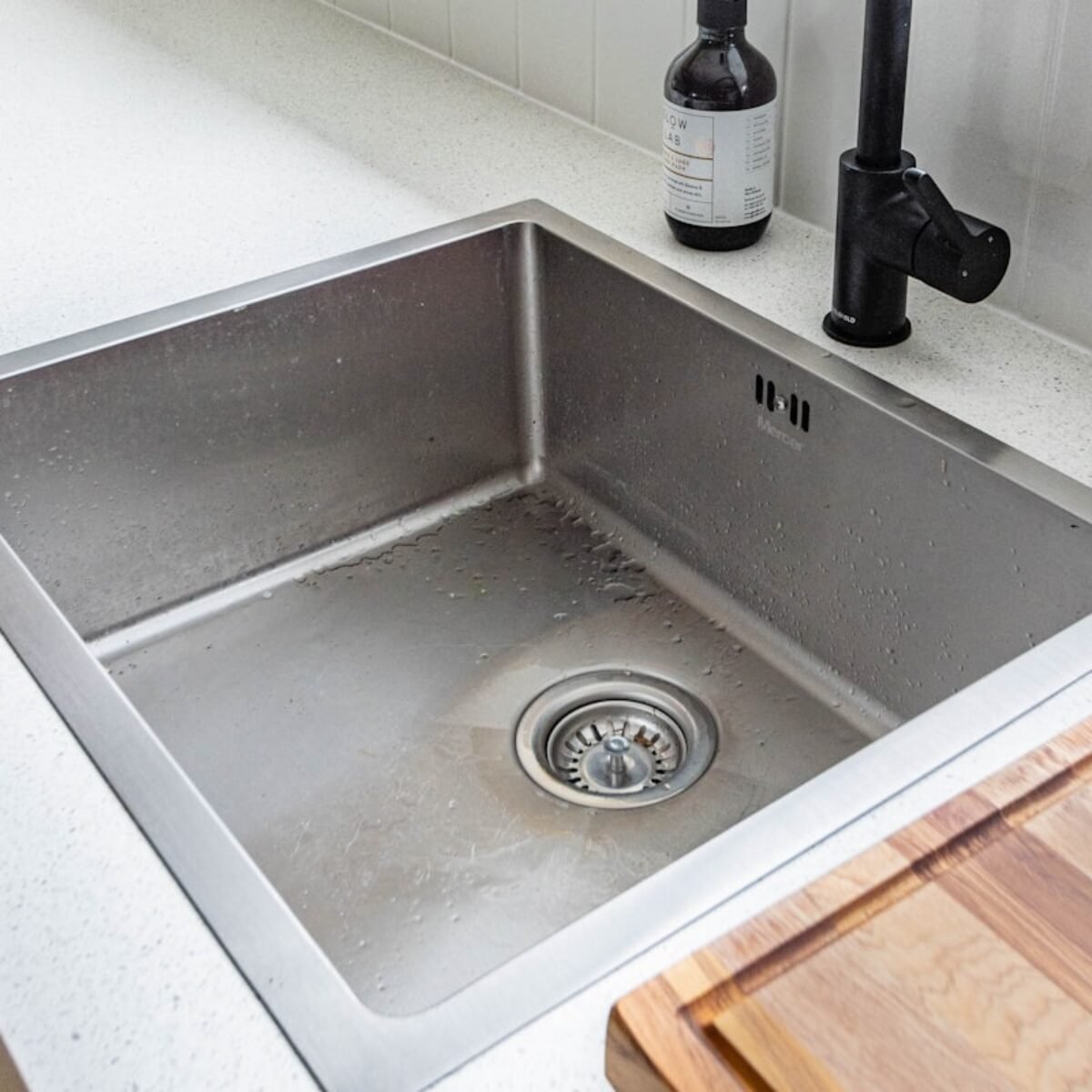 Stainless steel kitchen sink with mixer tap connected, square crop for kitchen installation about section