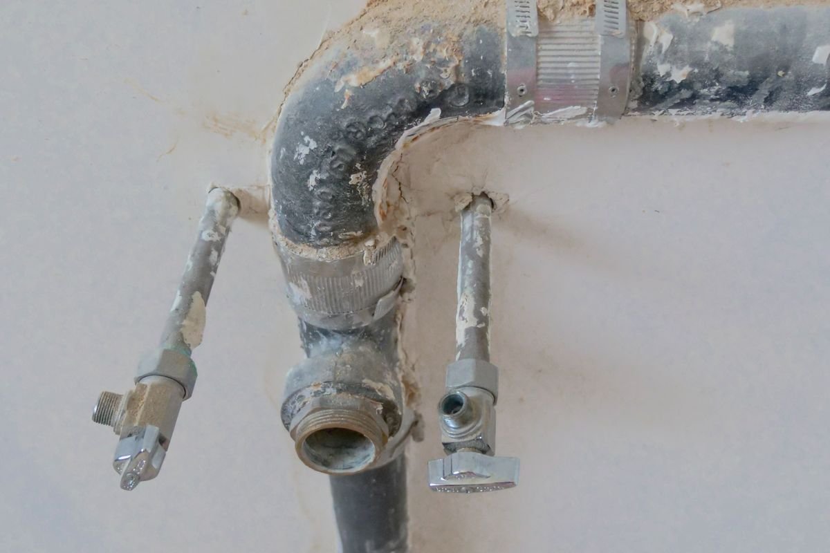 Exposed metal plumbing pipes on a wall