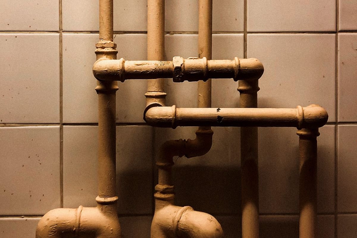 Vertical pipes against white tiling
