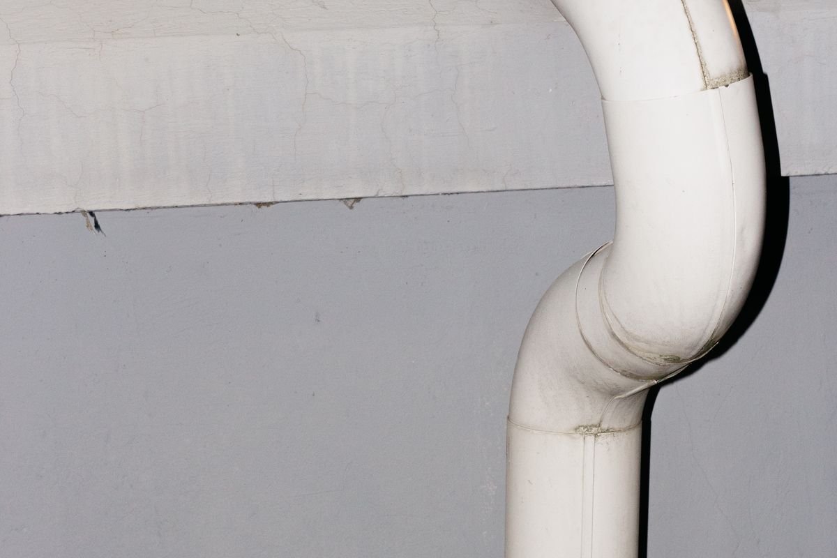 White drainage pipe against a wall