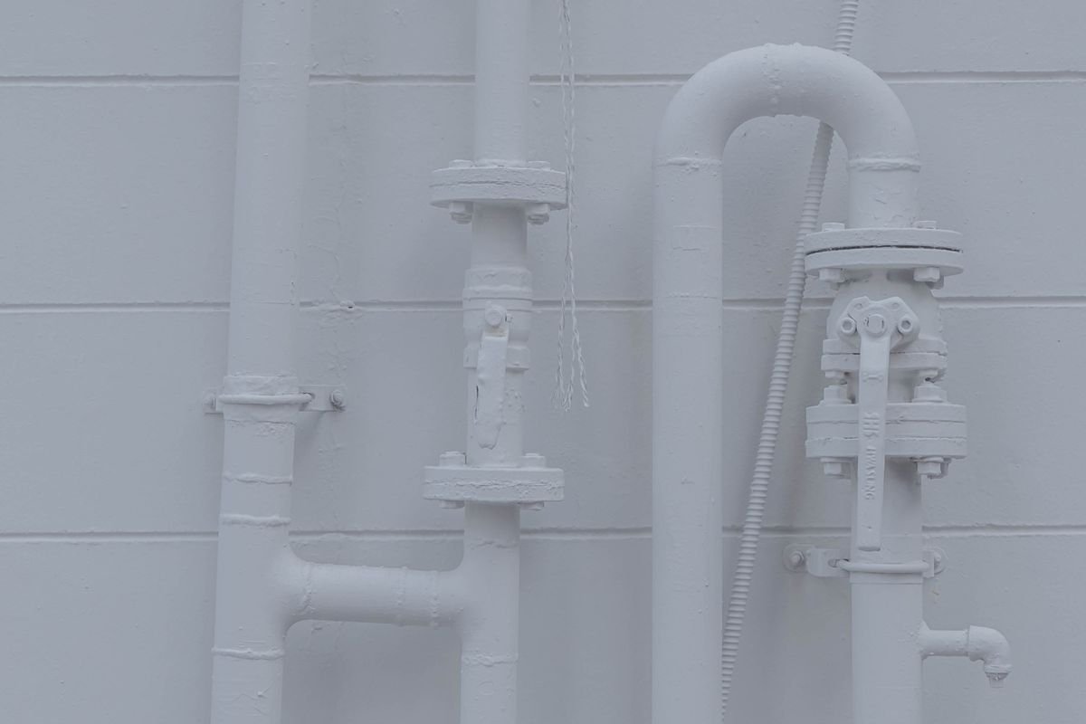 White plumbing pipes on a white wall
